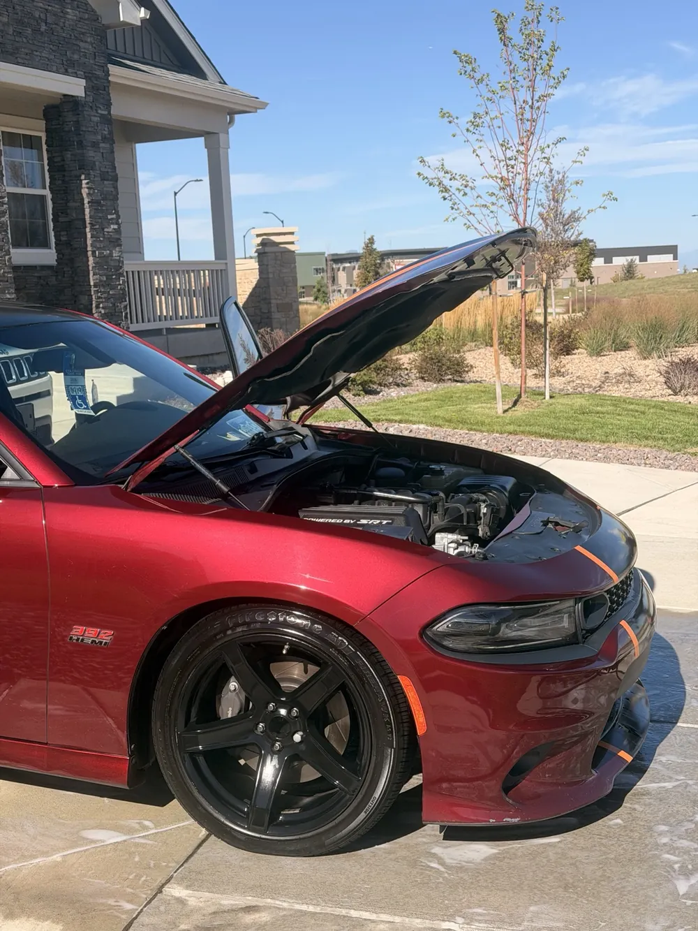 Deep red Dodge Charger with its hood raised
