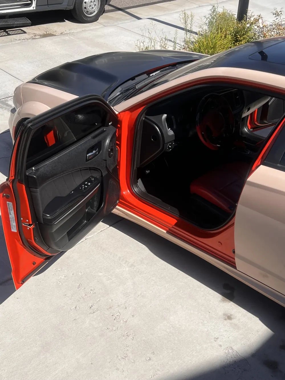 Red leather interior of a Dodge Charger with the doors opened during a detail